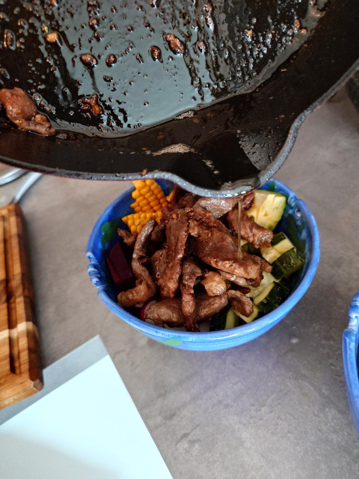 Seared beef tipped over the bowl