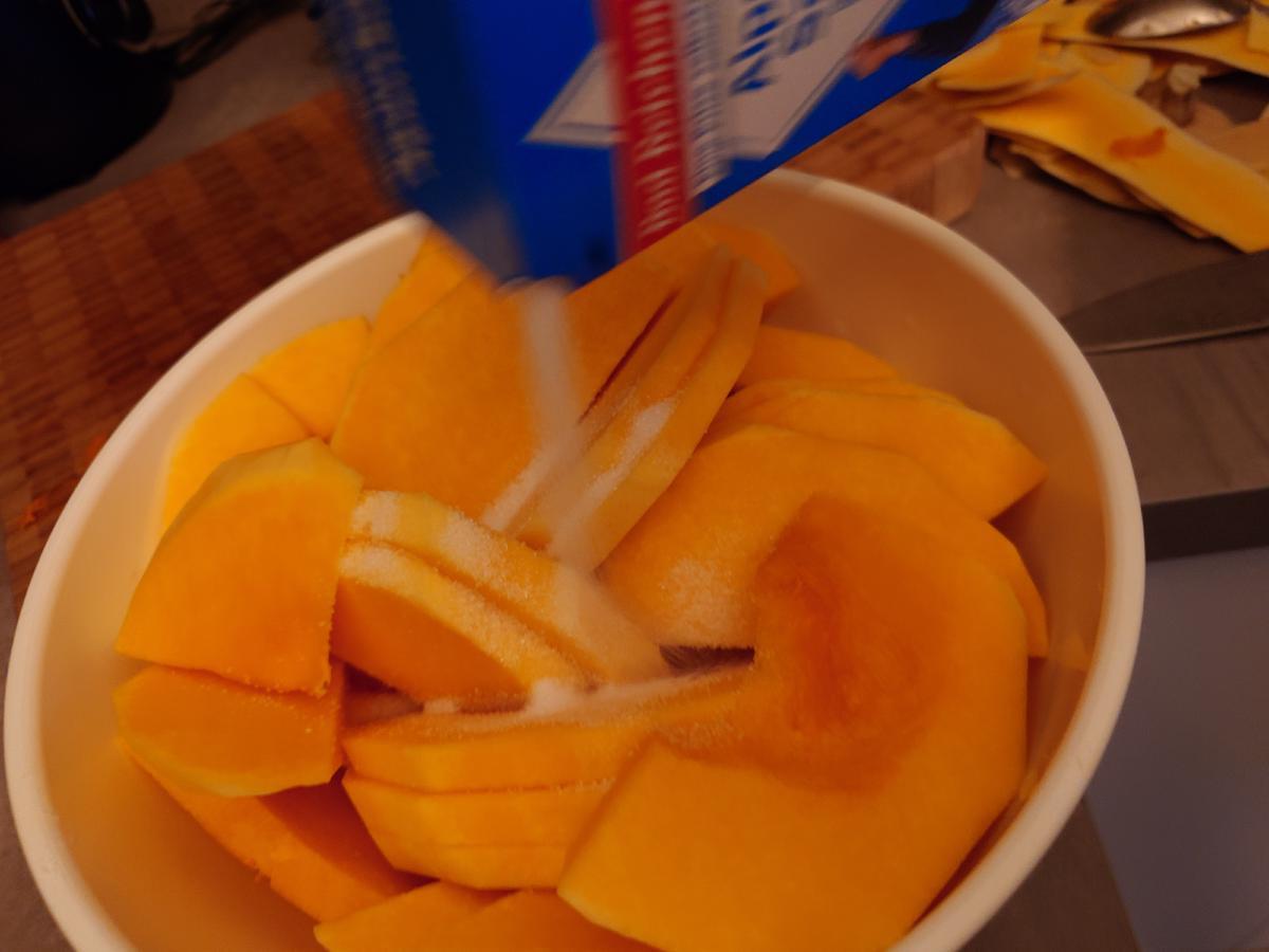 Salt poured from the box over sliced squash in a white bowl