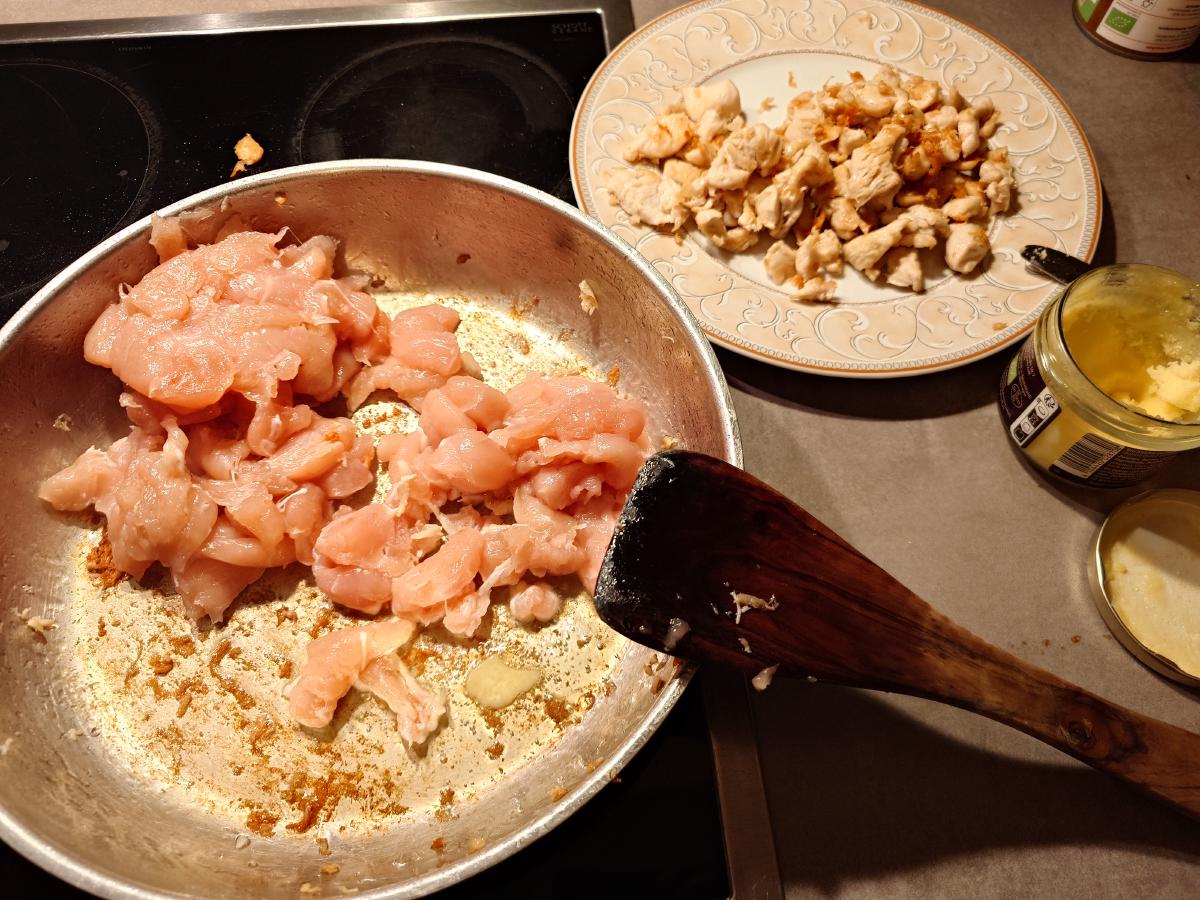 Raw chicken going in for the next batch, the cooked pile waiting on a plate