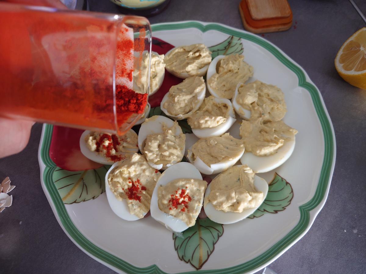 Paprika poured over the filled eggs