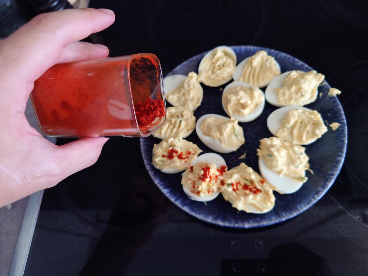 Paprika dusted over the filled eggs