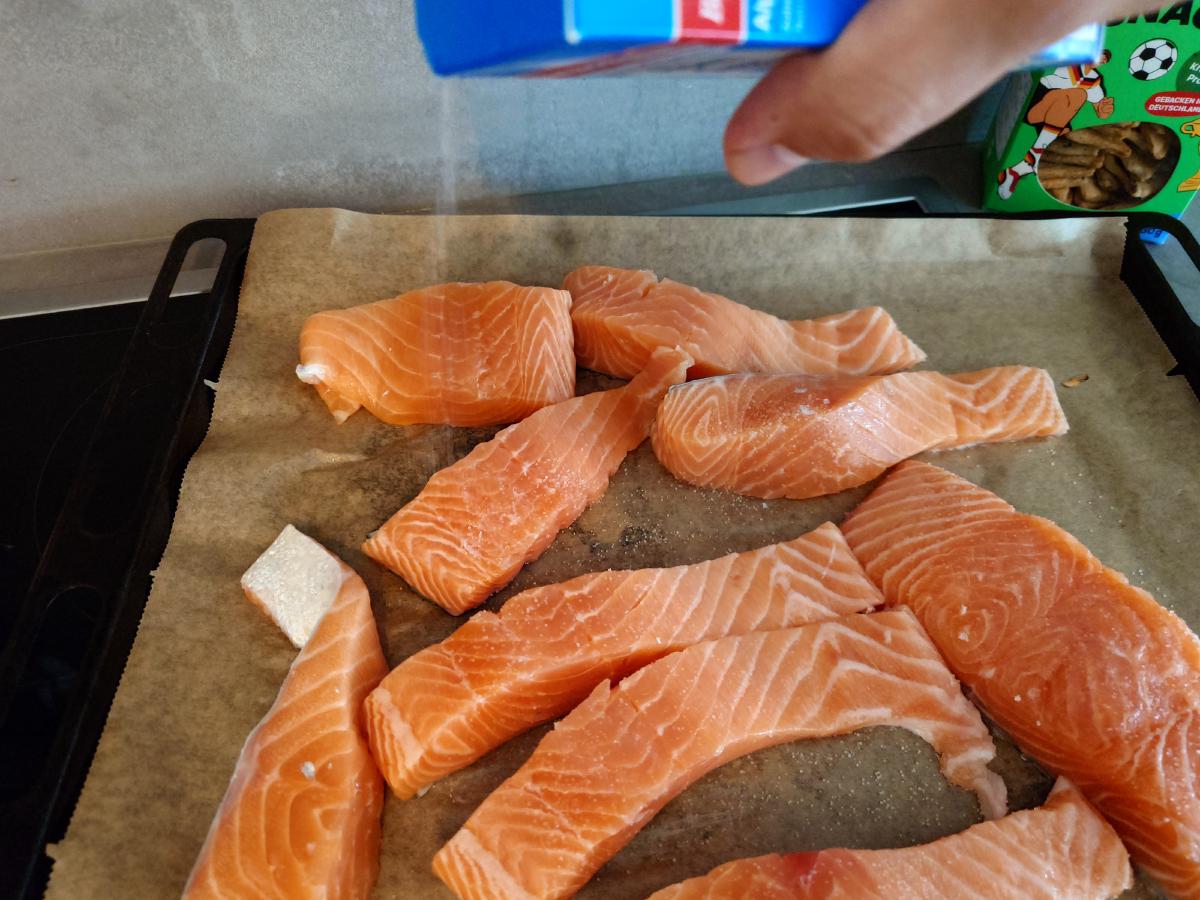Salmon cut into strips on the tray, salted