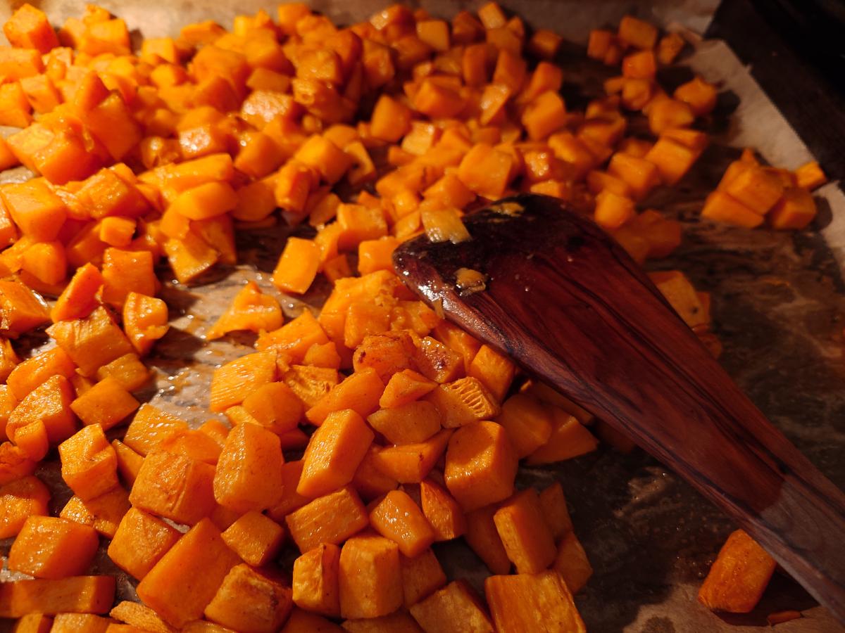 Sweet potatoes stirred, edges starting to catch