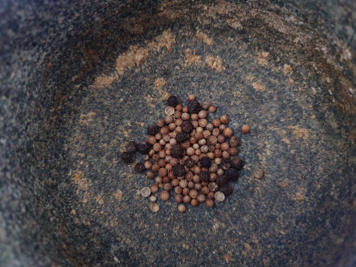 Coriander seed and black peppercorns in the mortar