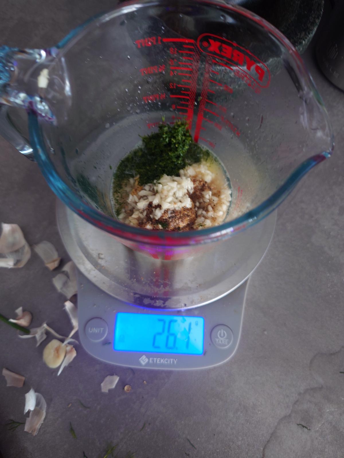 The jug filling out, dill and garlic loose in the liquid