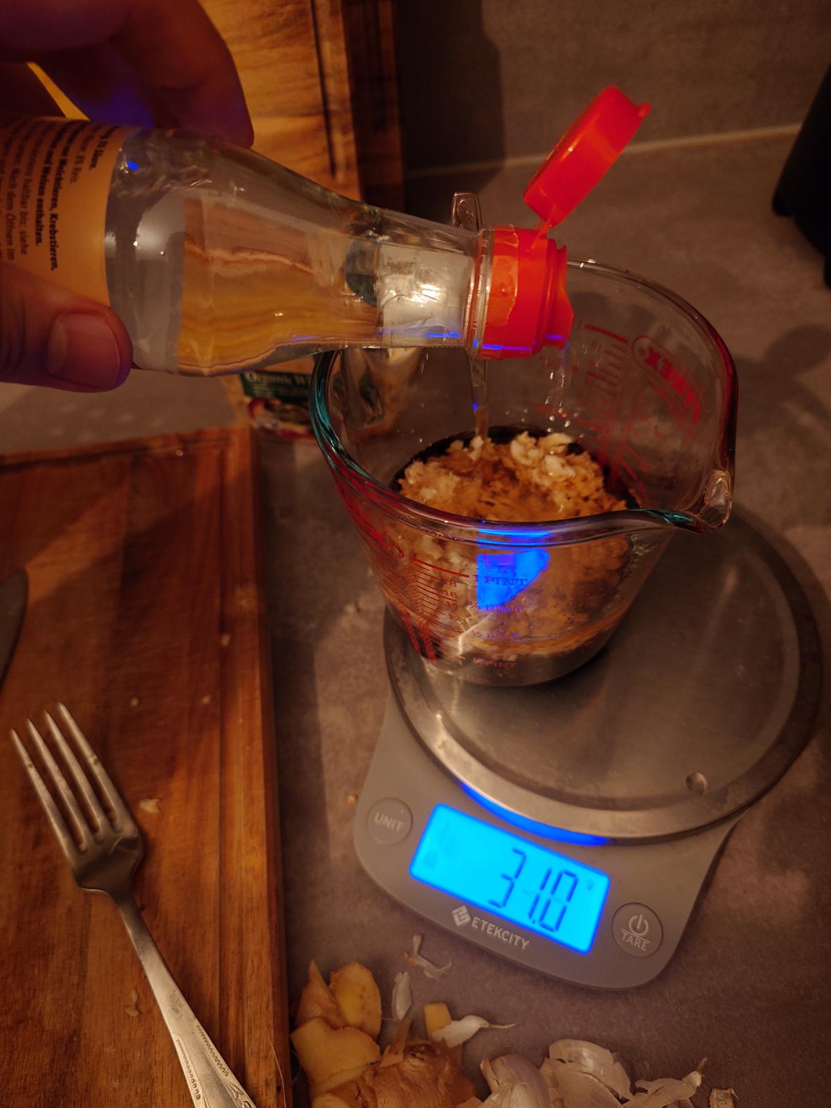 Rice vinegar poured into the jug from a bottle with a red flip cap