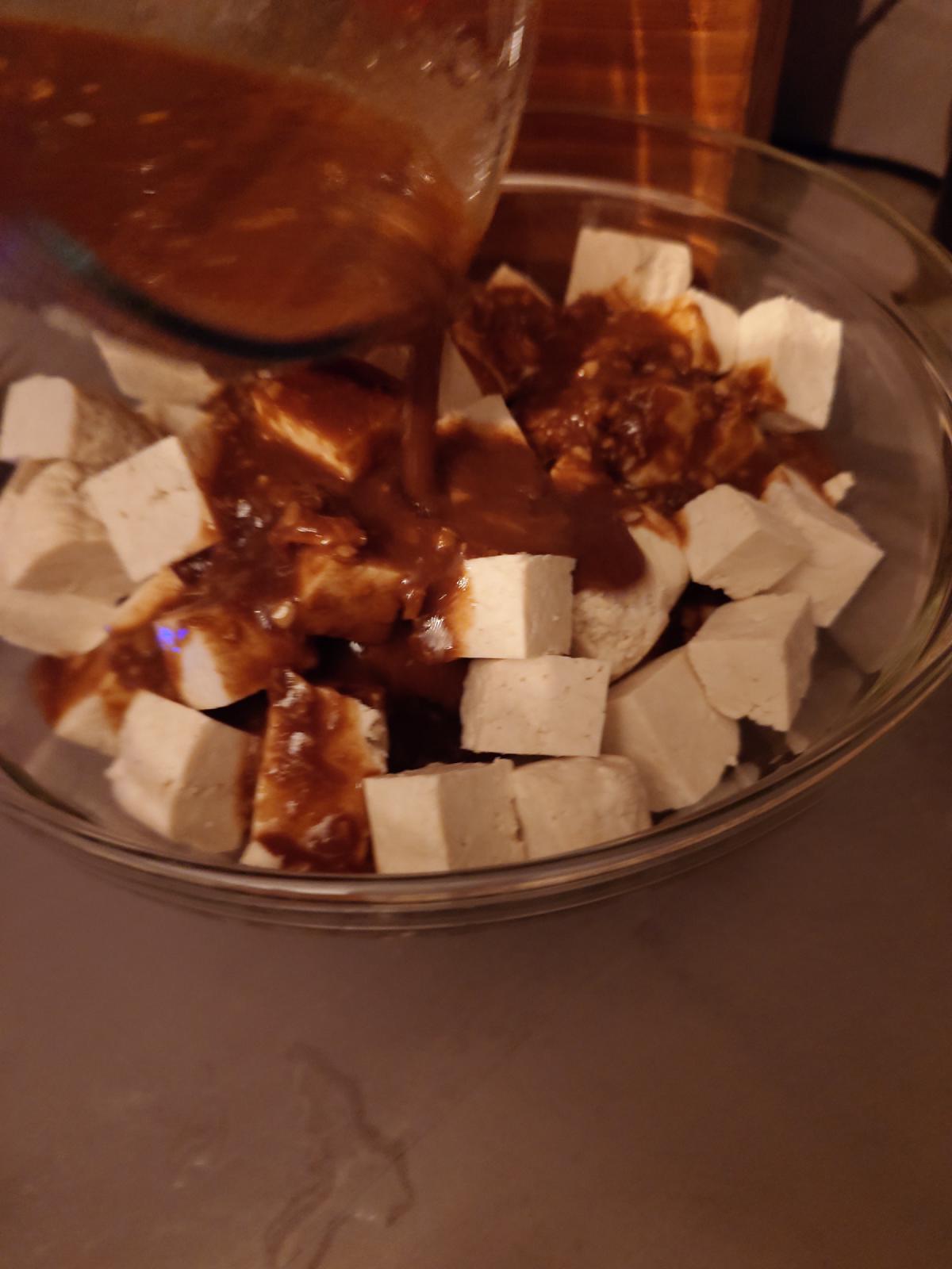 The jug tipped over the bowl of tofu cubes