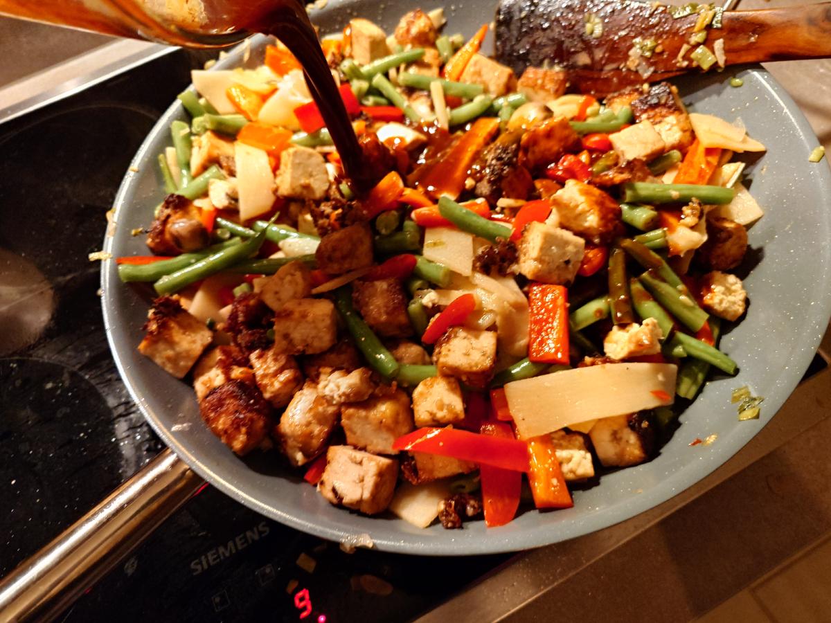 The dark sauce poured around the edge of the wok