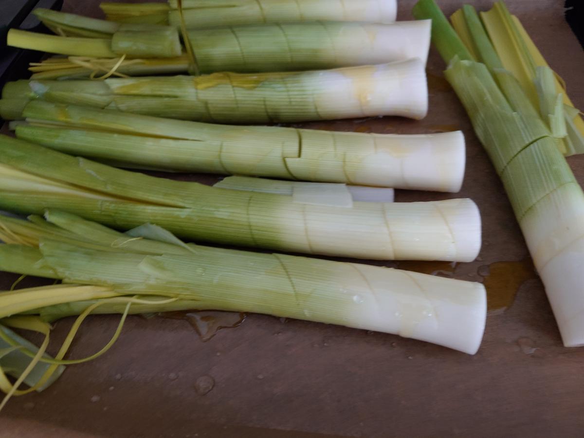 The scored leeks oiled on the board, oil pooling in the cut lines