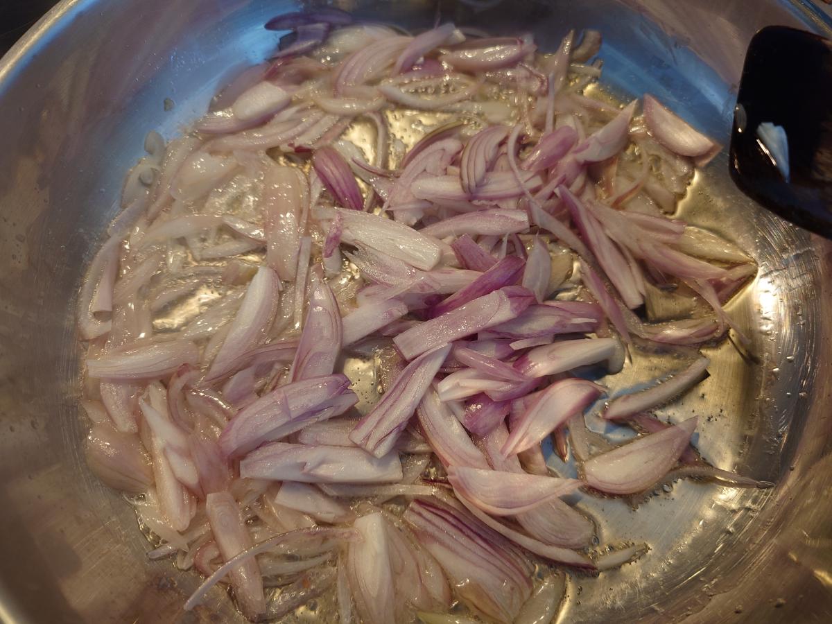 Raw shallot chunks spread in the hot oil