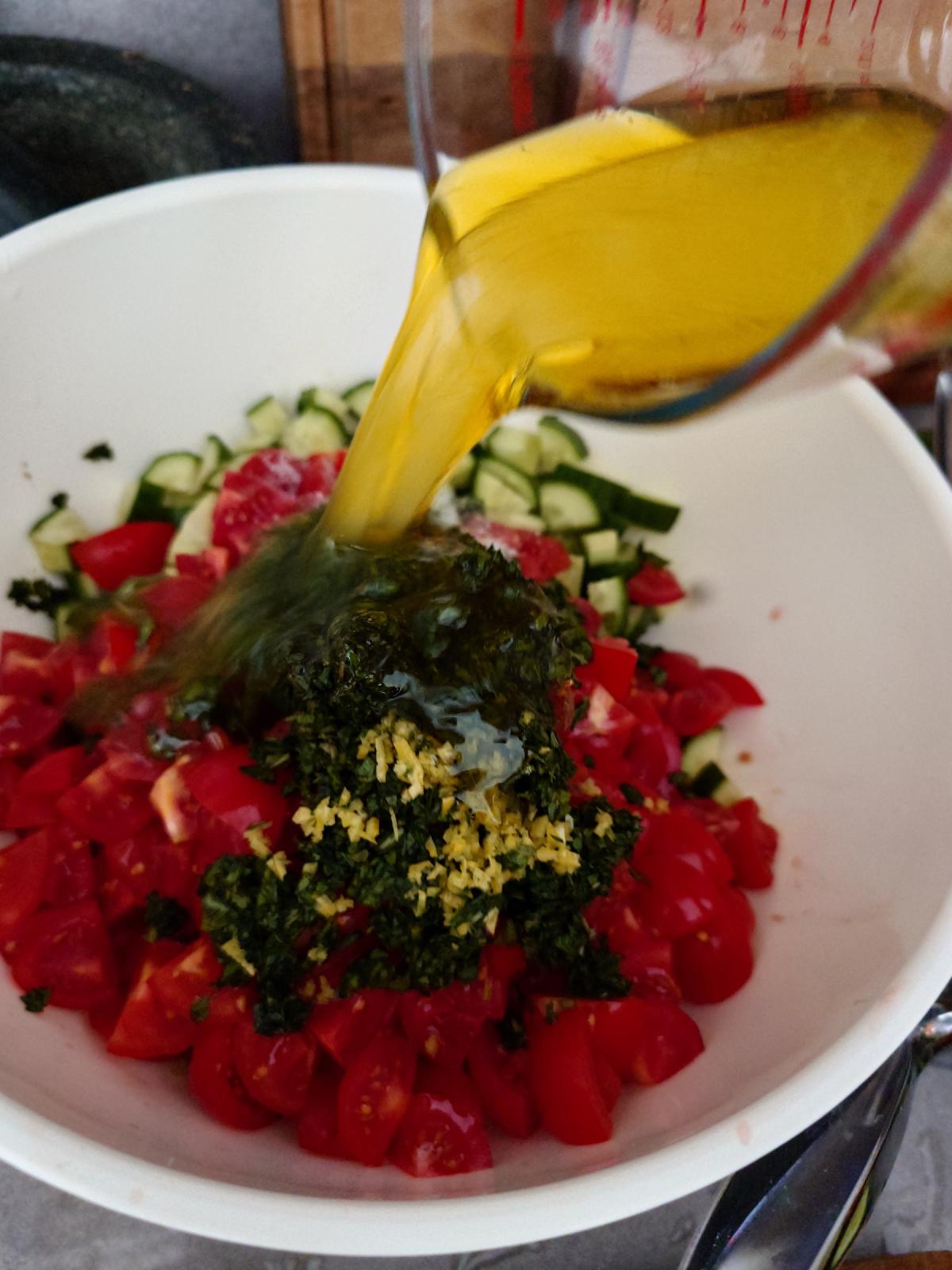 The oil and lemon poured from the measuring jug over the salad