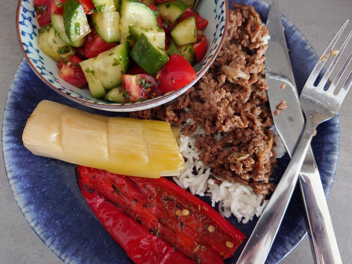 The plate: spiced beef over rice, a roasted leek and a roasted pepper, salad in a separate bowl