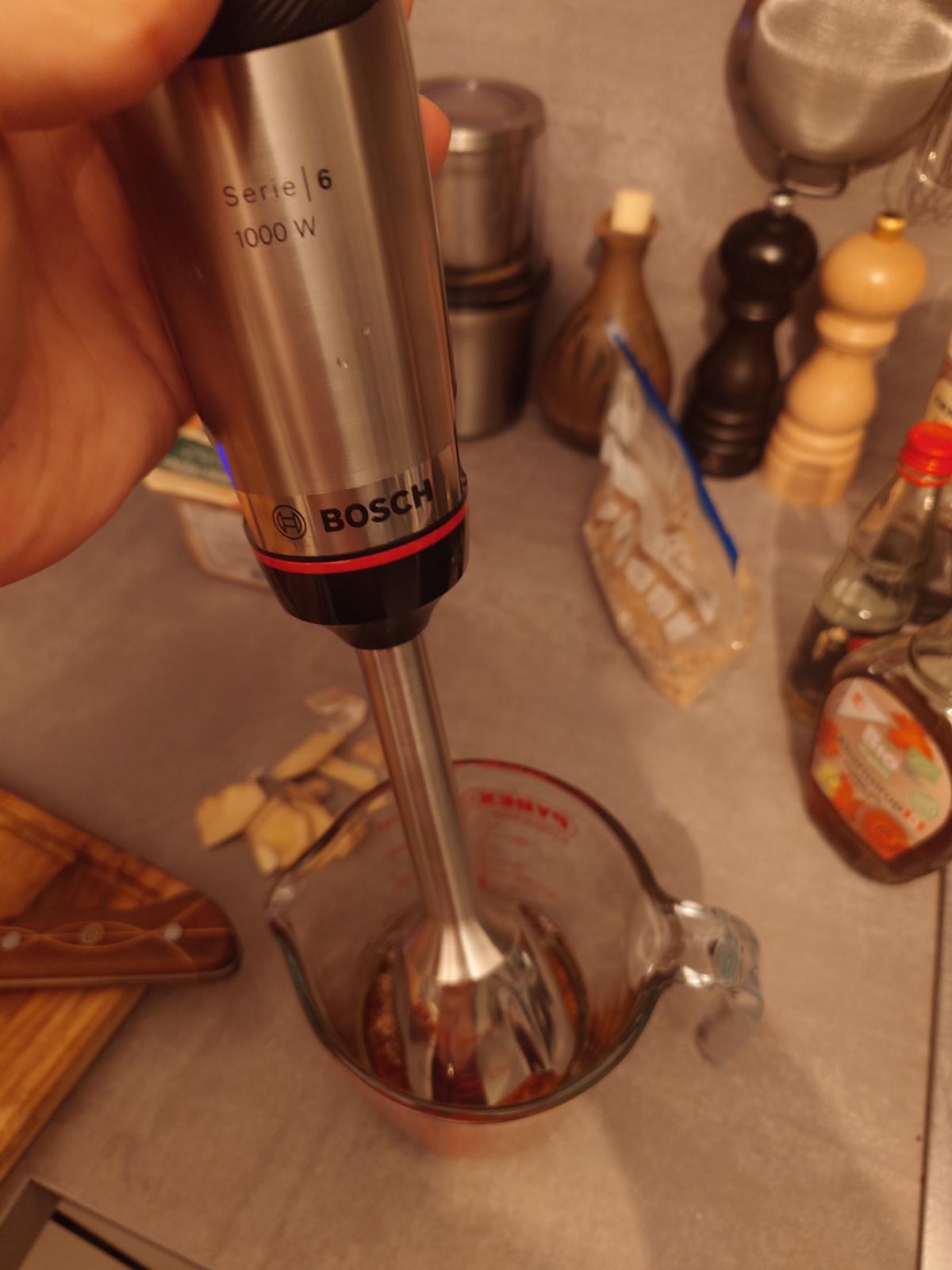 The immersion blender going into the cup