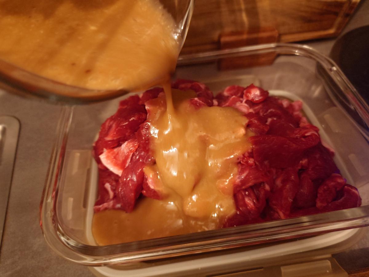 The blended marinade poured over the sliced beef