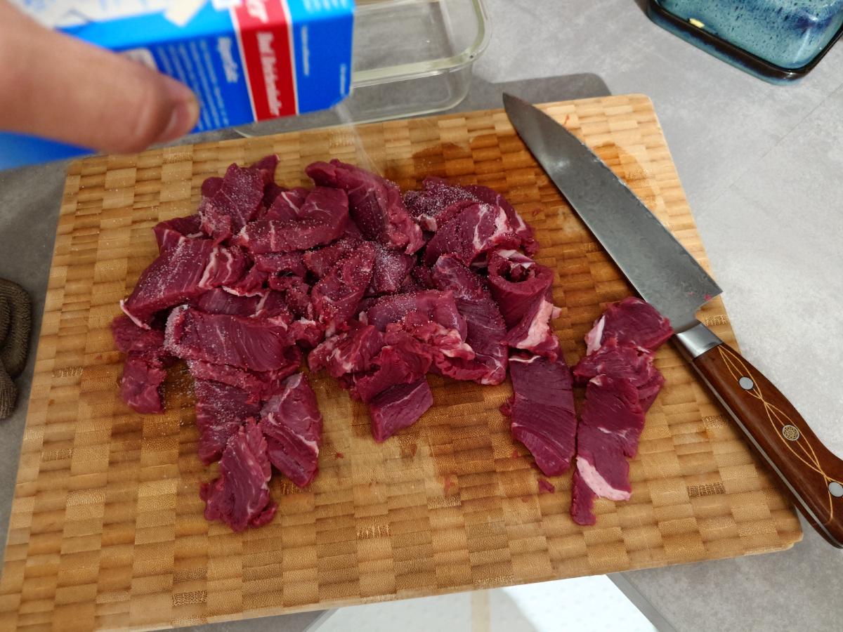 Beef sliced thin and salted on the board