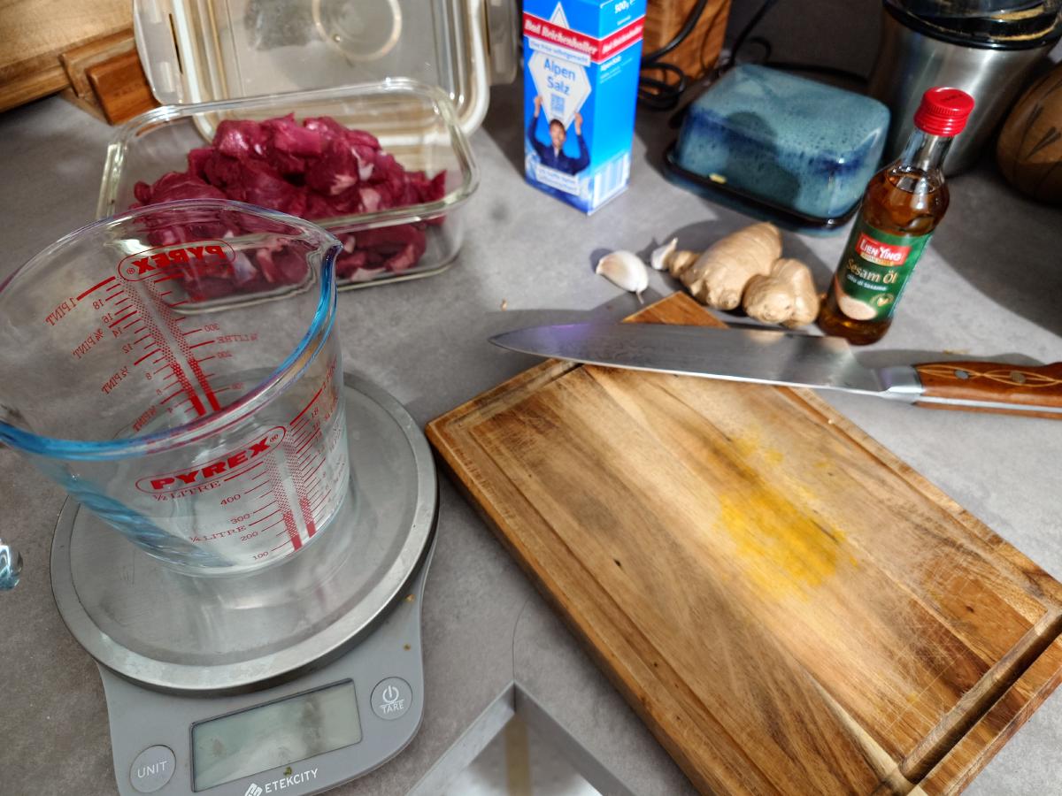 Sliced beef packed away, ginger and garlic waiting on the board