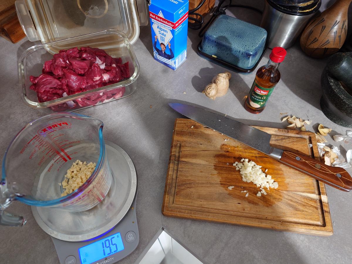 Minced ginger weighed in the cup, garlic being chopped