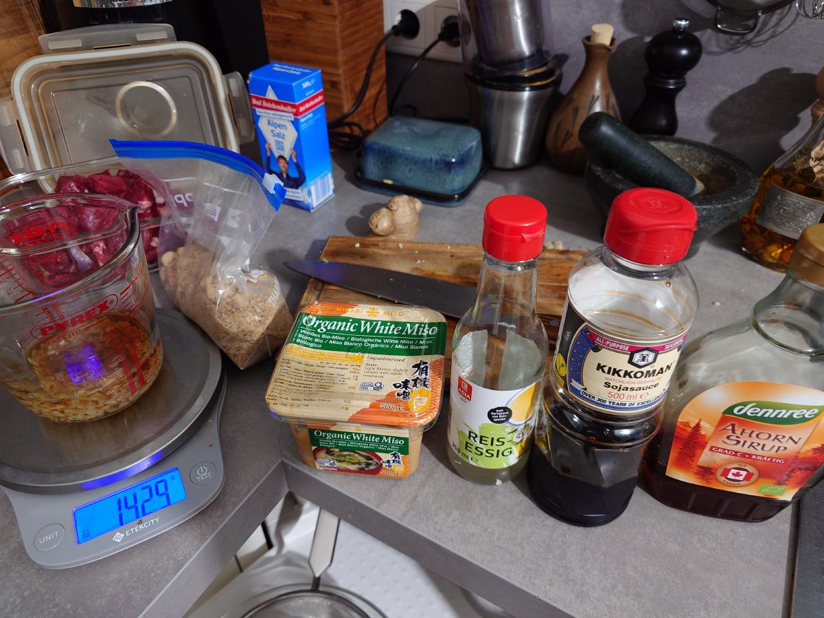 White miso, vinegar, soy sauce and maple syrup lined up, sesame oil already in the cup
