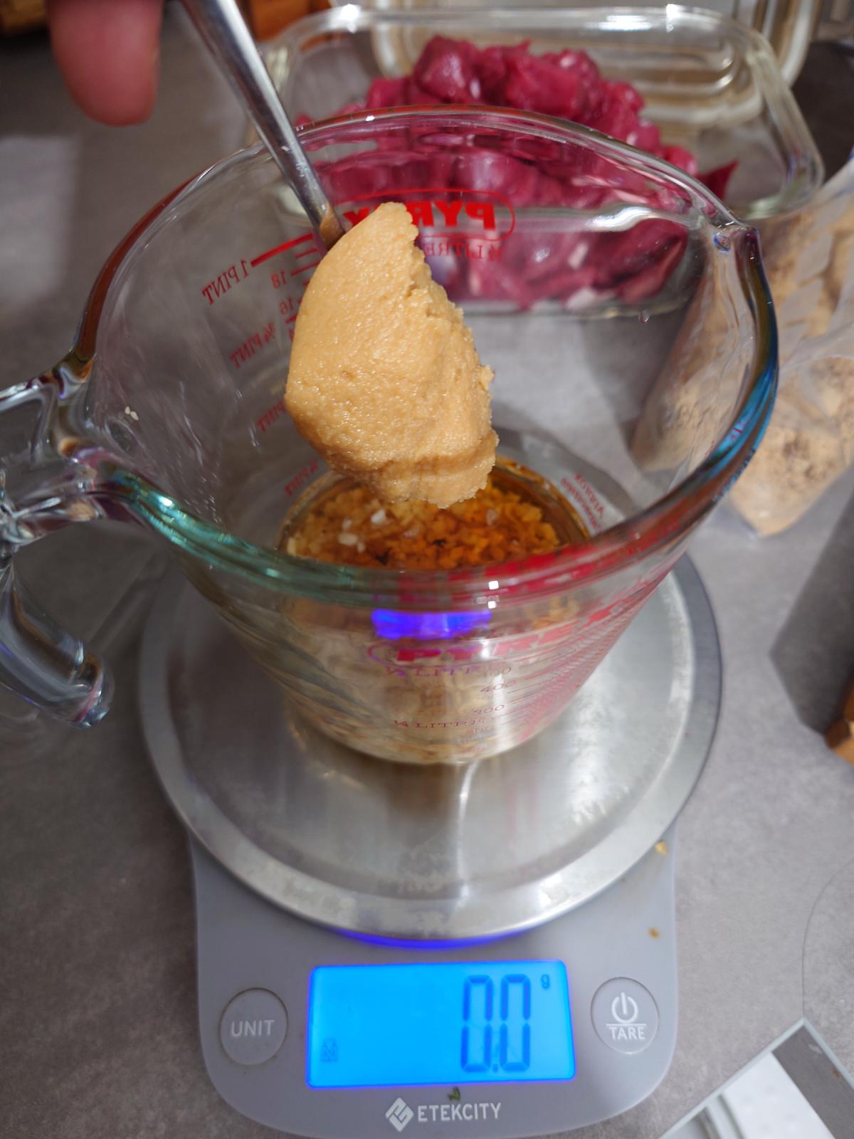 A spoon of white miso going into the cup
