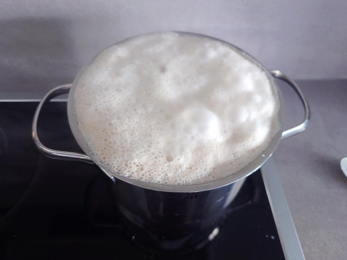 The pot filled to the rim with white foam, about to go over