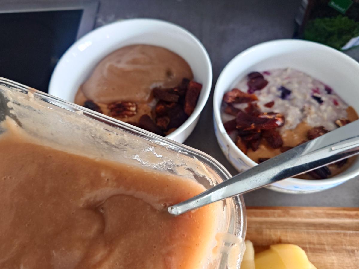 Two bowls with peanut butter, pecans and apricots, the tub of apple pear sauce alongside