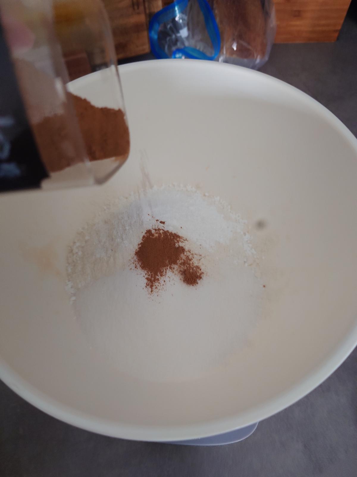 Cinnamon ground into the bowl from the mill, sitting on the white powders