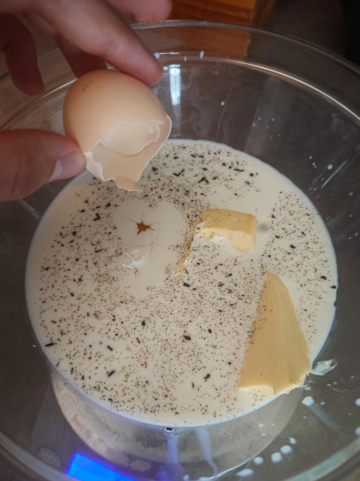 Egg cracked into the milk and butter