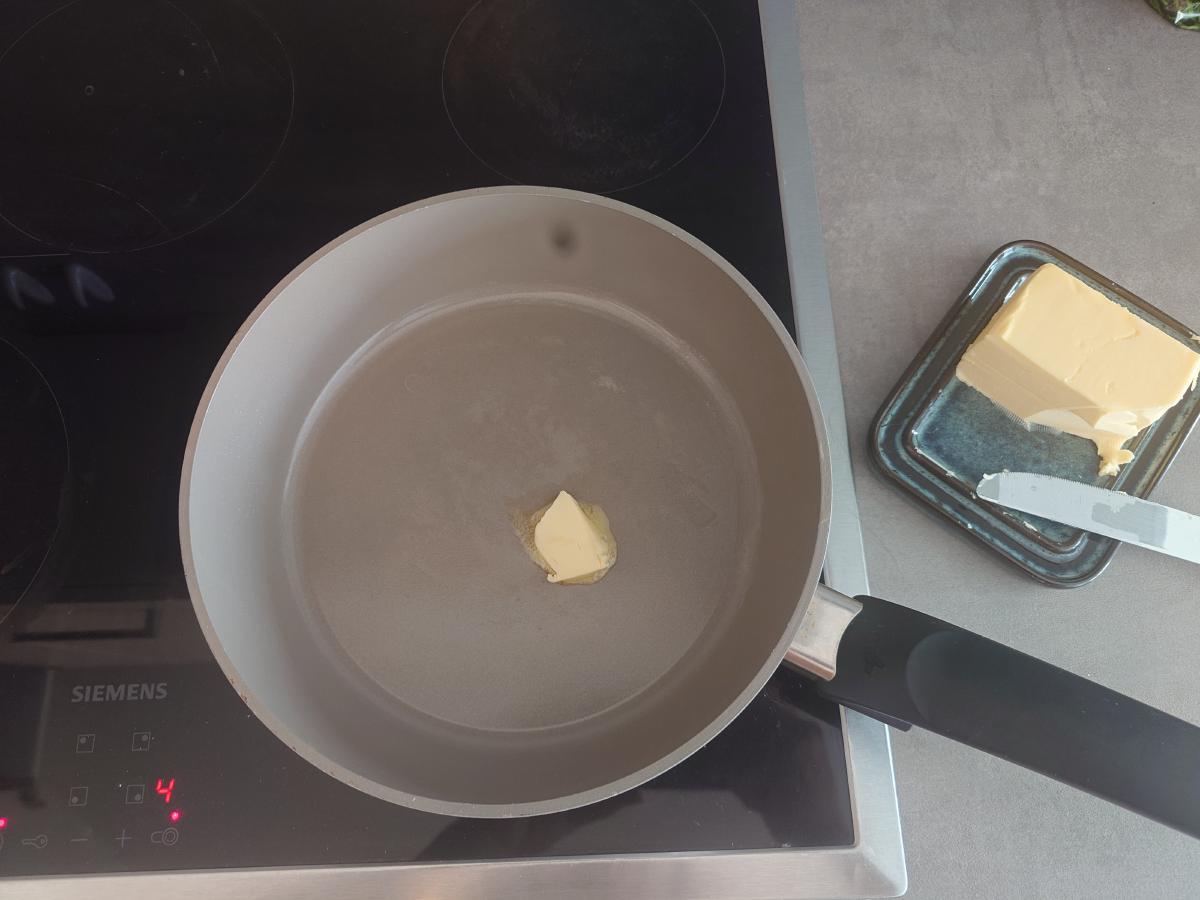 A knob of butter in the pan on low heat