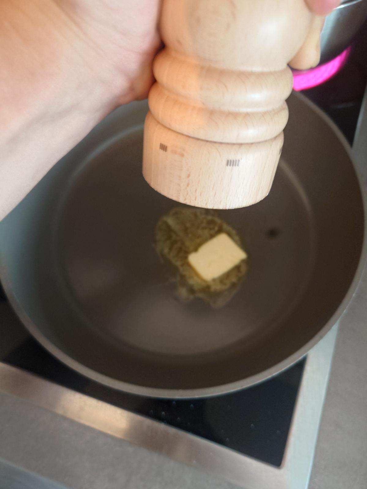 Salt ground onto the butter melting in the pan