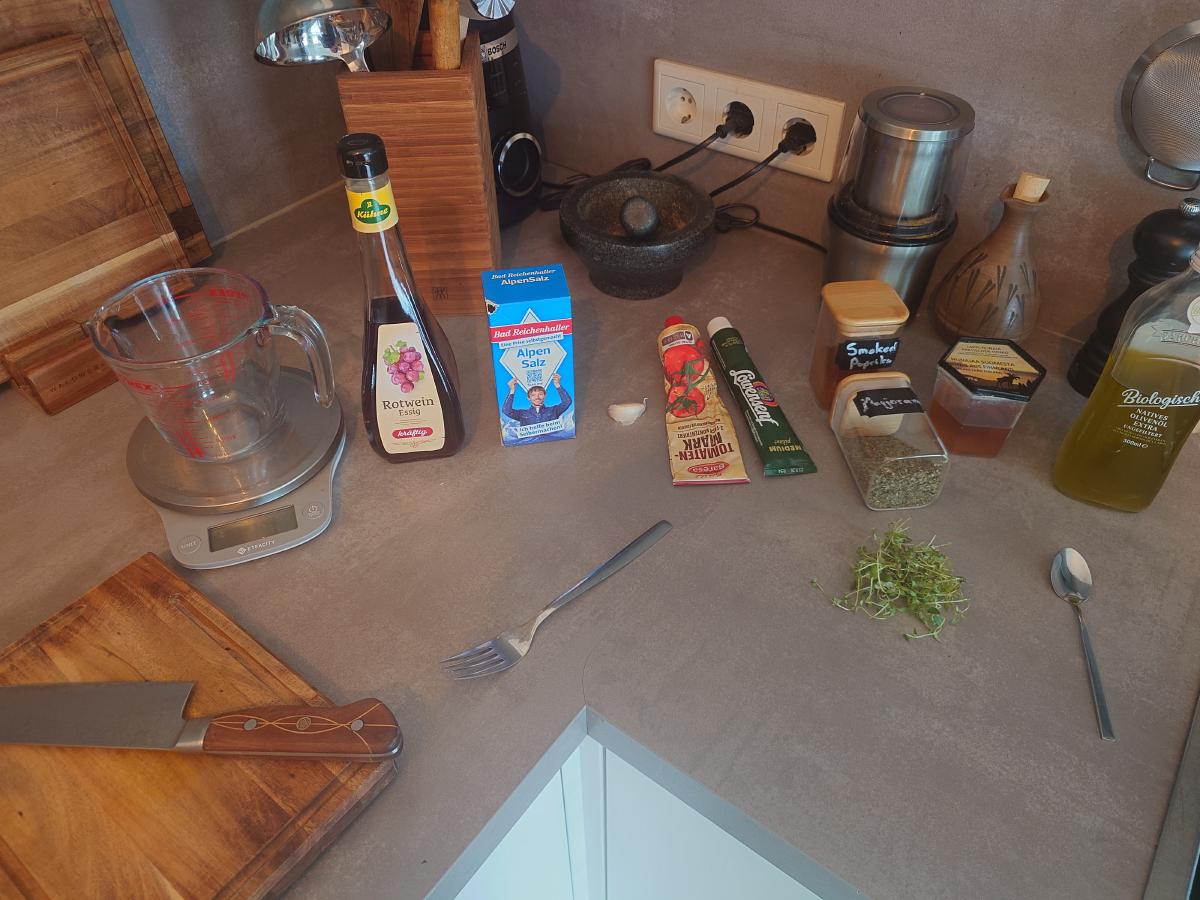 Vinegar, salt, tomato paste, mustard, paprika, marjoram, honey and oil set out