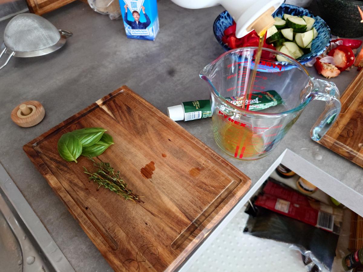 Basil and thyme on the board next to the measuring cup