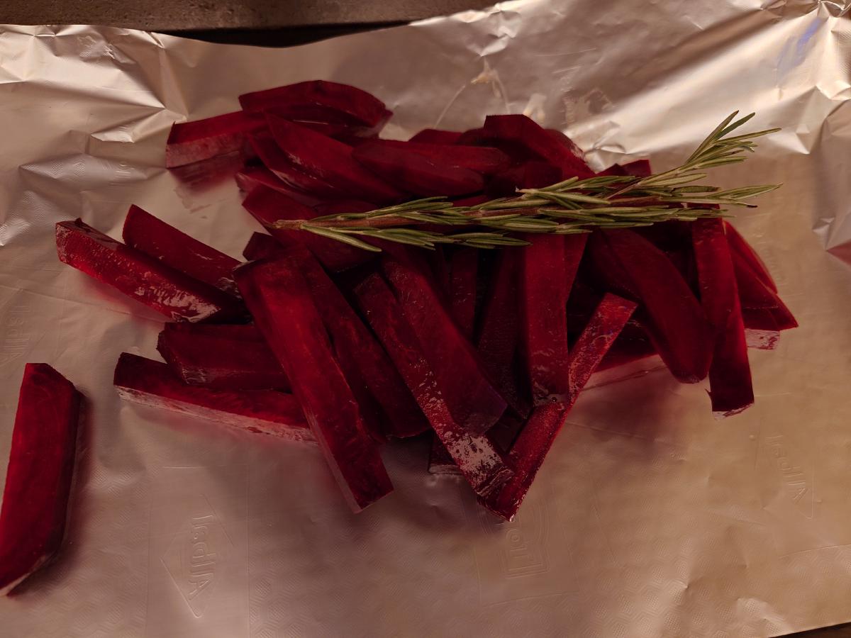 Beet batons on foil with a rosemary sprig laid across