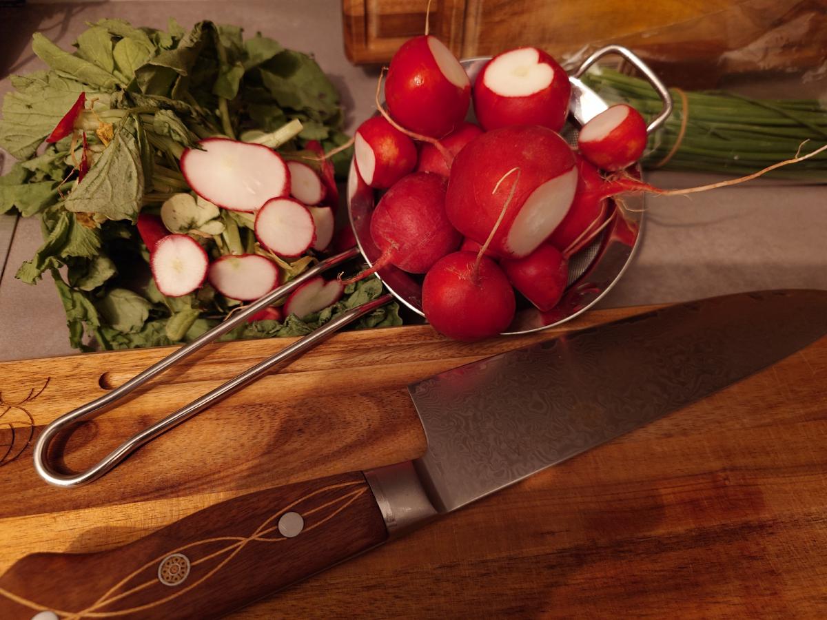 Radishes and chives on the counter with the knife