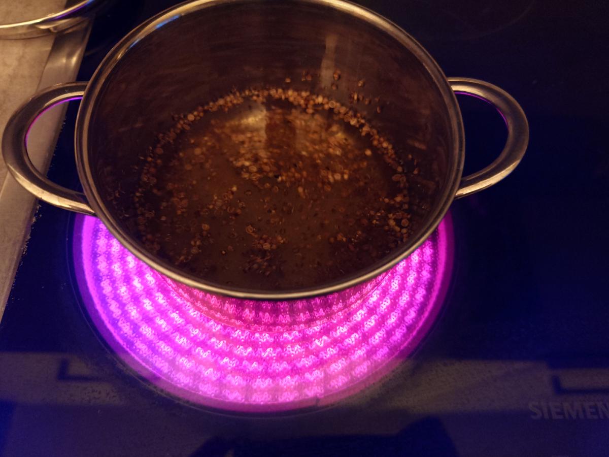 The brine warming on the hob, coriander floating on top