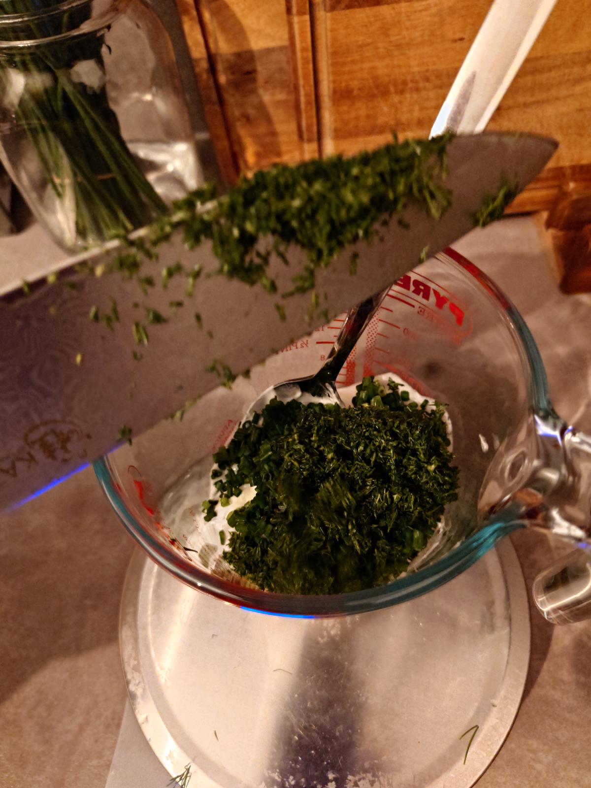 Chopped dill going into the yogurt