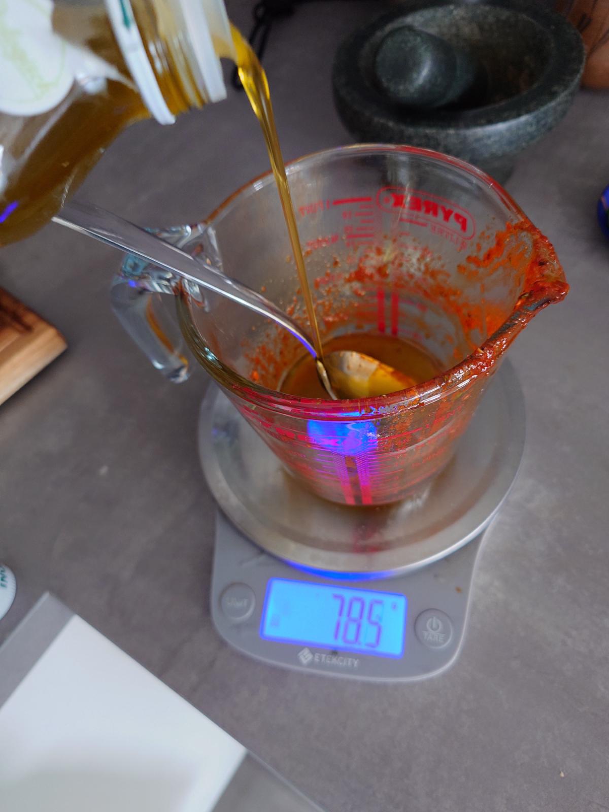 Olive oil poured into the cup the marinade came out of