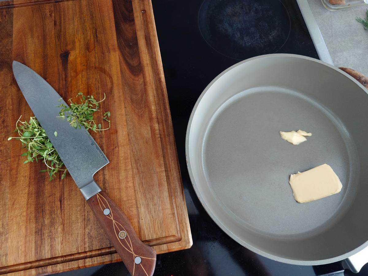 Thyme chopped on the board, butter in the nonstick pan