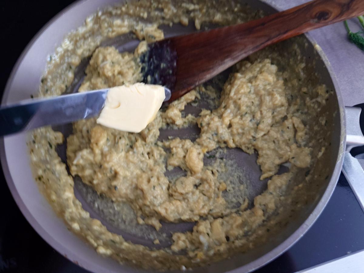 A knob of butter going into the finished eggs