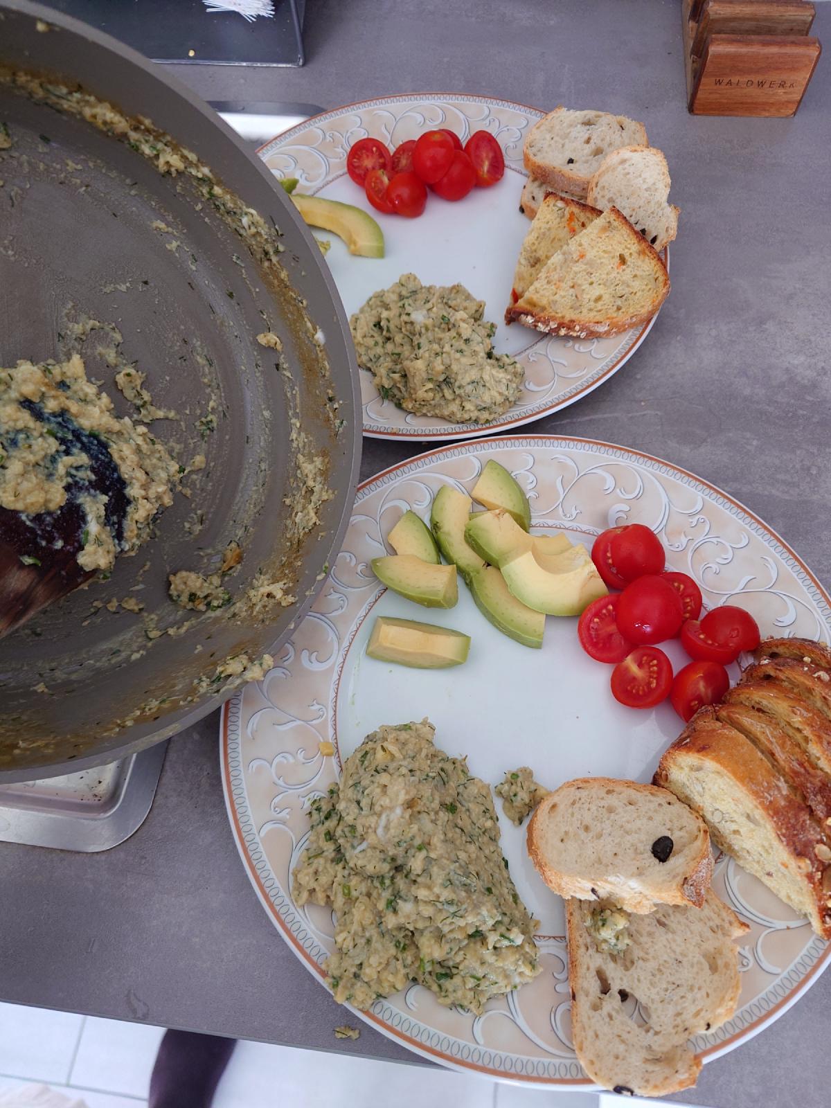 Plates with eggs, tomatoes, avocado and bread