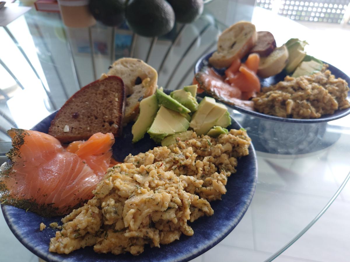 Plated soft scrambled eggs with smoked salmon, avocado and toast