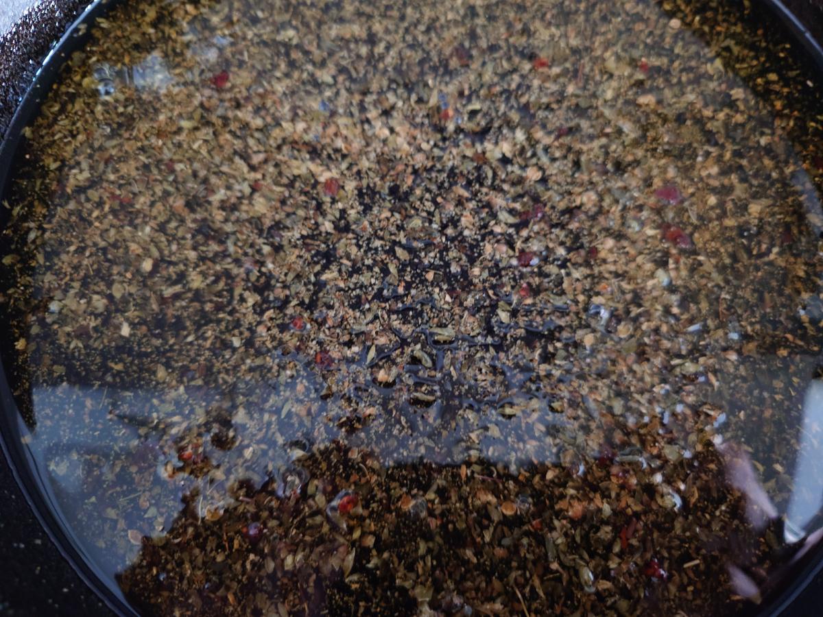 The finished oil, spices spread across the base of the pan