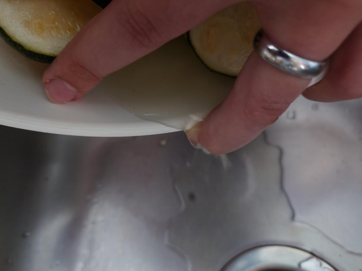 The bowl tilted over the sink, liquid running from under the slices