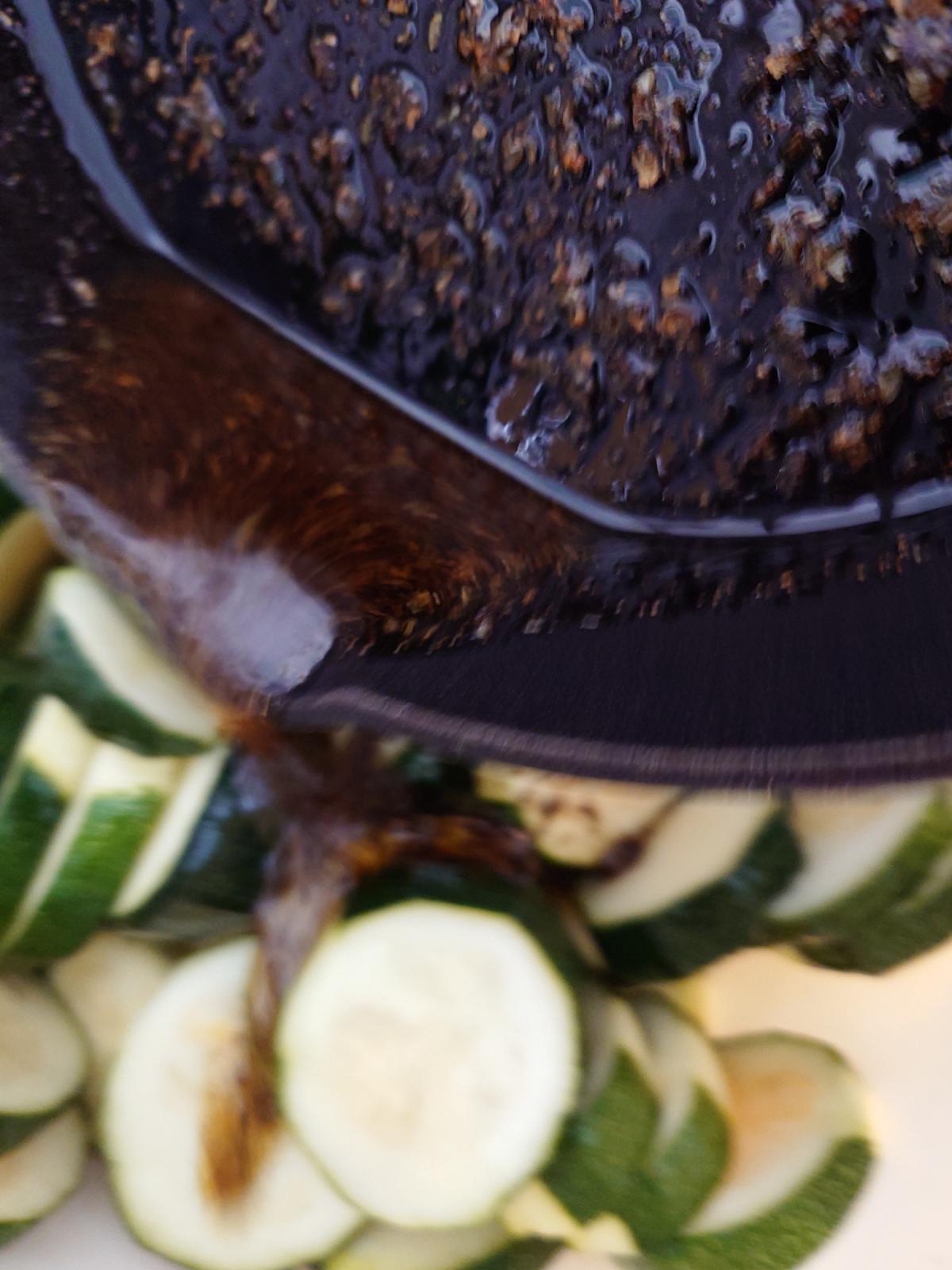 The pan tipped over the bowl of rounds, dark oil running down