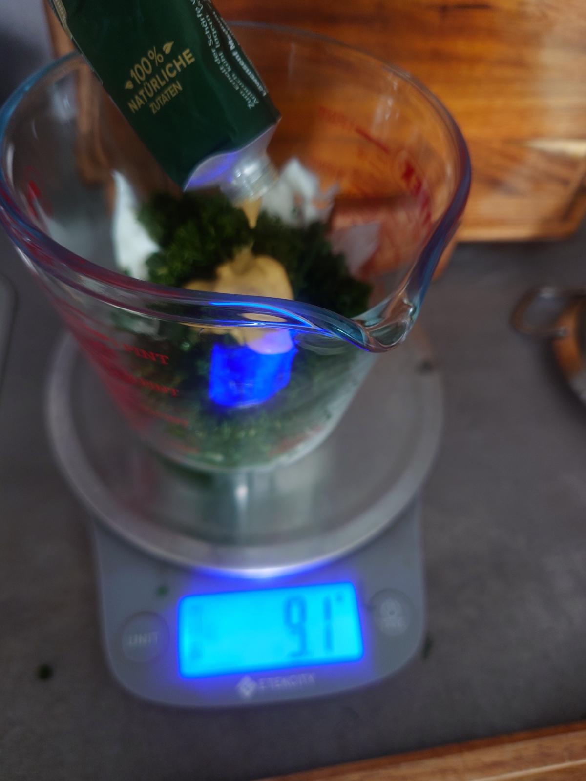 Mustard squeezed from a tube into the jug, scale reading 9.1 g