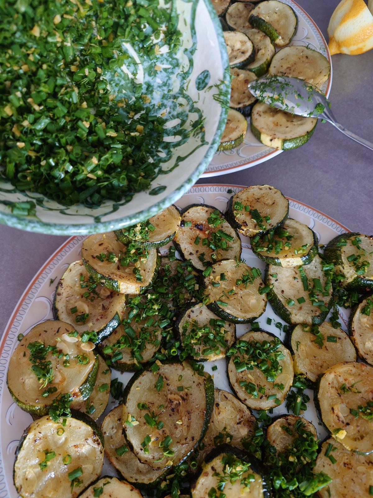 The herb mix spooned from its bowl over two plates of roasted rounds