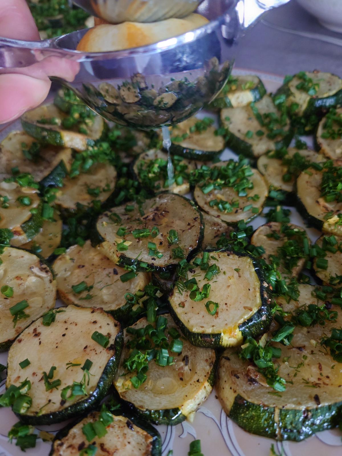 Lemon juice poured over the herbed rounds from a small glass bowl