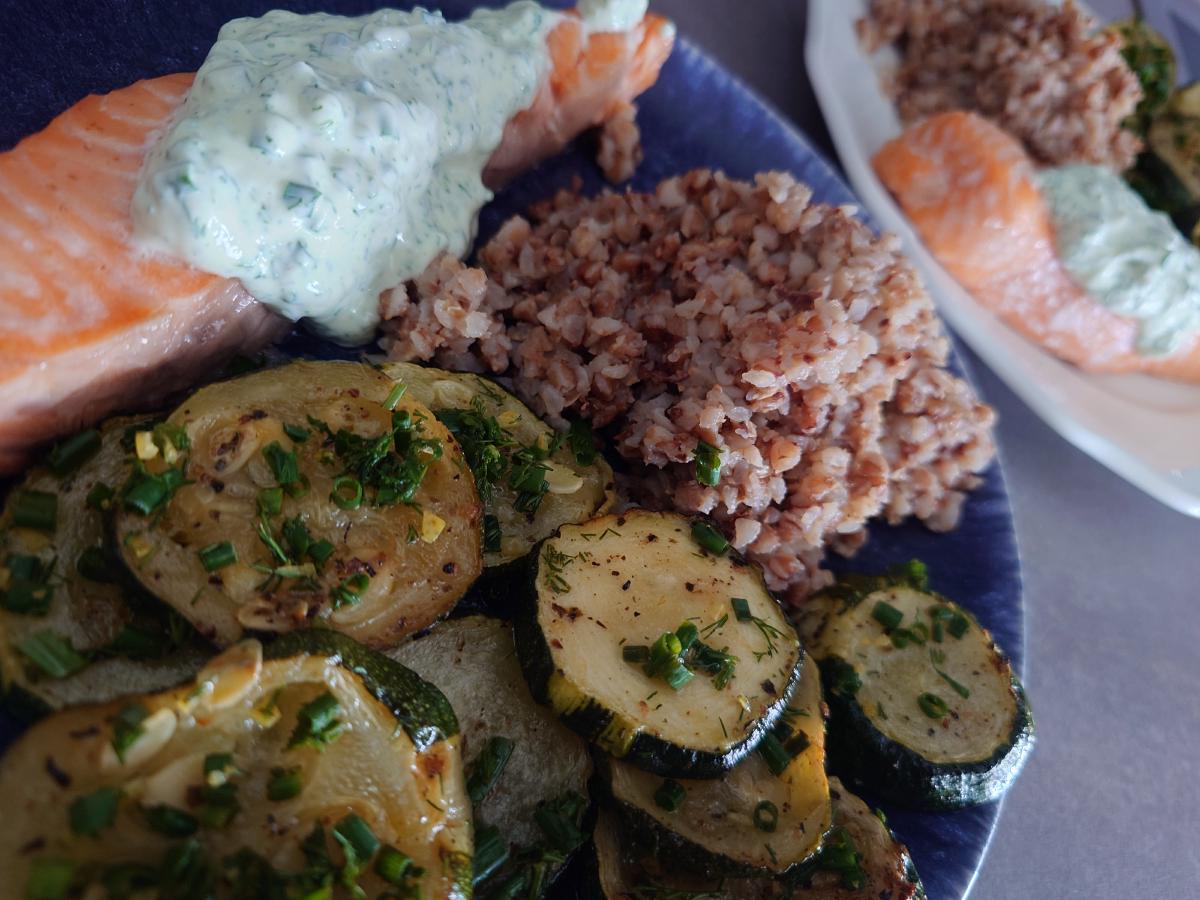 Salmon under the dill yogurt sauce beside buckwheat and the herbed zucchini rounds