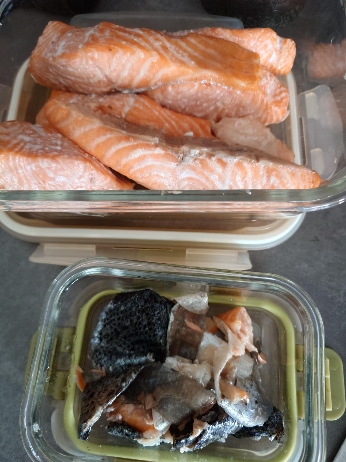 Leftover salmon in one glass container, the saved skins in a smaller one below